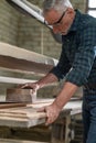 Carpenter hewing the wood and looking involved Royalty Free Stock Photo