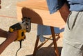 Carpenter and his assistant cutting the beech wood step for an indoor staircase with a jigsaw