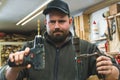 A carpenter holding an electrical drill machine and a hand drill comparing both Royalty Free Stock Photo