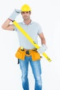 Carpenter holding spirit level while wearing hard hat Royalty Free Stock Photo