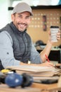 carpenter holds coffee while working in carpentry workshop Royalty Free Stock Photo