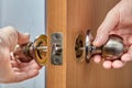 Carpenter inserts one half of the doorknob In through the latch