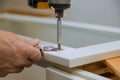 Carpenter installers a cabinet door hinge improvement view installed a new kitchen Royalty Free Stock Photo