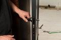 A carpenter installs a metal doorknob for an interior door, Royalty Free Stock Photo