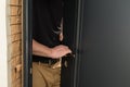 A carpenter installs a metal doorknob for an interior door, Royalty Free Stock Photo