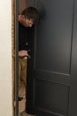 A carpenter installs a metal doorknob for an interior door Royalty Free Stock Photo
