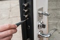 Arpenter installs a reliable burglar-resistant lock in the metal door. Royalty Free Stock Photo