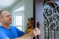 The carpenter installs a reliable resistant lock in the metal door. Royalty Free Stock Photo