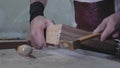 A carpenter joins two wooden parts made using the technology of a dovetail with a hammer. Detail of a carpenter with dovetail