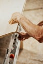 Carpenter lifting a sheet of wood to access controls below Royalty Free Stock Photo