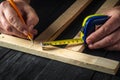Carpenter makes pencil marks on a block of wood. Hands of the master close-up at work. Working environment in a carpentry workshop Royalty Free Stock Photo