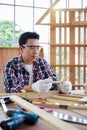 Carpenter making birdhouse. Carpenter with ruler measuring wood plank at workshop