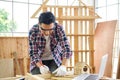 Carpenter making birdhouse. Carpenter with pencil and ruler measuring wood plank at workshop