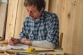 Carpenter making woodwork project notes on clipboard paper