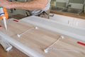 Carpenter male using construction glue when working with wooden white painted board, closeup, carpentry, woodwork, profession,