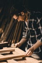 Carpenter man attend to making masterpiece woodworks handcrafted furniture fine measure in wood workshop, Vertical shot