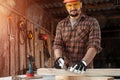 Carpenter man notes with a pencil on the board marks for cutting, male hands with a pencil closeup on a wooden board. Woodwork Royalty Free Stock Photo