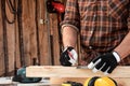 Carpenter man notes with a pencil on the board marks for cutting, male hands with a pencil closeup on a wooden board. Woodwork Royalty Free Stock Photo