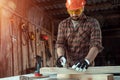 Carpenter man notes with a pencil on the board marks for cutting, male hands with a pencil closeup on a wooden board. Woodwork Royalty Free Stock Photo