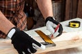 Carpenter man notes with a pencil on the board marks for cutting, male hands with a pencil closeup on a wooden board. Woodwork Royalty Free Stock Photo