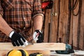 Carpenter man notes with a pencil on the board marks for cutting, male hands with a pencil closeup on a wooden board. Woodwork Royalty Free Stock Photo