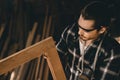 Carpenter man professional skilled in wood work looking detail of masterpiece woodcraft in furniture workshop Royalty Free Stock Photo