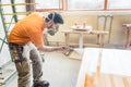 Carpenter man spraying varnish on a table he works on