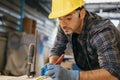 Carpenter man wear gloves using tape measure and pencil to make marks piece of wood for cut Royalty Free Stock Photo