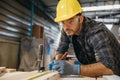 Carpenter man wear gloves during working using tape measure and pencil to make marks piece of wood Royalty Free Stock Photo