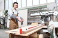 Carpenter man work in the carpentry, with cordless drill driver screw a board, protected with ear muffs Royalty Free Stock Photo