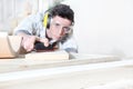 Carpenter man work in carpentry, sanding wooden boards with sandpaper, protected with ear muffs and glasses Royalty Free Stock Photo