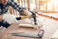 Carpenter Man is Working Timber Woodworking in Carpentry Shop, Craftsman is Hammering a Nail into Timber Frame for Wooden