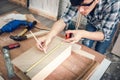 Carpenter Man is Working Timber Woodworking in Carpentry Workshops, Craftsman is Using Tape Measure to Measuring Timber Frame for