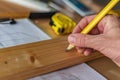 Carpenter marking pine wood plank for cutting Royalty Free Stock Photo