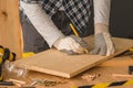 Carpenter marking pine wood plank for cutting Royalty Free Stock Photo