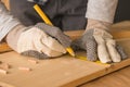 Carpenter marking pine wood plank for cutting Royalty Free Stock Photo