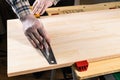 Carpenter marks cutting line on wooden board