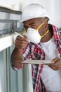 carpenter in mask checking state ceiling Royalty Free Stock Photo