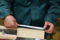 The carpenter measures the dimensions of the object with a tape