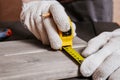 Carpenter is measuring length of wood planks or timbers by measuring tape or ruler. Carpenter workspace, craftsman entrepreneur Royalty Free Stock Photo