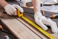 Carpenter is measuring length of wood planks or timbers by measuring tape or ruler. Carpenter workspace, craftsman entrepreneur Royalty Free Stock Photo