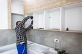 Carpenter measuring shelves that are parts of new kitchen with meter Royalty Free Stock Photo