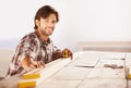 Carpenter, measuring tape and wood in workshop, smile and happiness for job, service and plan. Man, working and builder Royalty Free Stock Photo