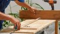 Carpenter measuring a wooden plank with a milometer Royalty Free Stock Photo