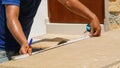 Carpenter Measuring a Wooden Plank