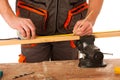 A carpenter measuring a wooden plank in a workshop isolated over Royalty Free Stock Photo