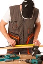 A carpenter measuring a wooden plank in a workshop isolated over Royalty Free Stock Photo