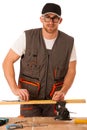 A carpenter measuring a wooden plank in a workshop isolated over Royalty Free Stock Photo