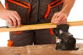 A carpenter measuring a wooden plank in a workshop isolated over Royalty Free Stock Photo