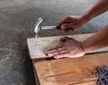 The Carpenter nailing wood board to make furniture